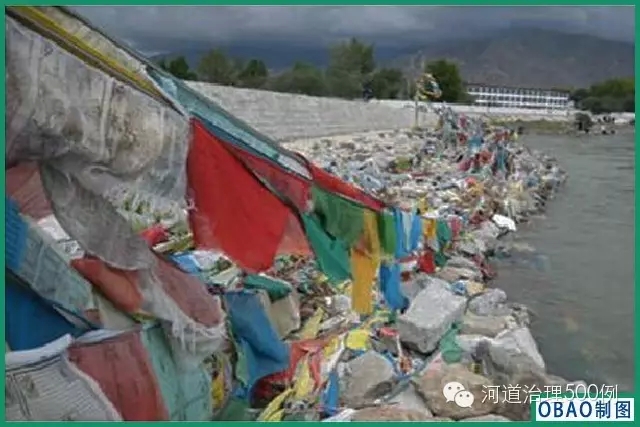 掛在石籠護岸上的經幡，失去了表達的自然載體